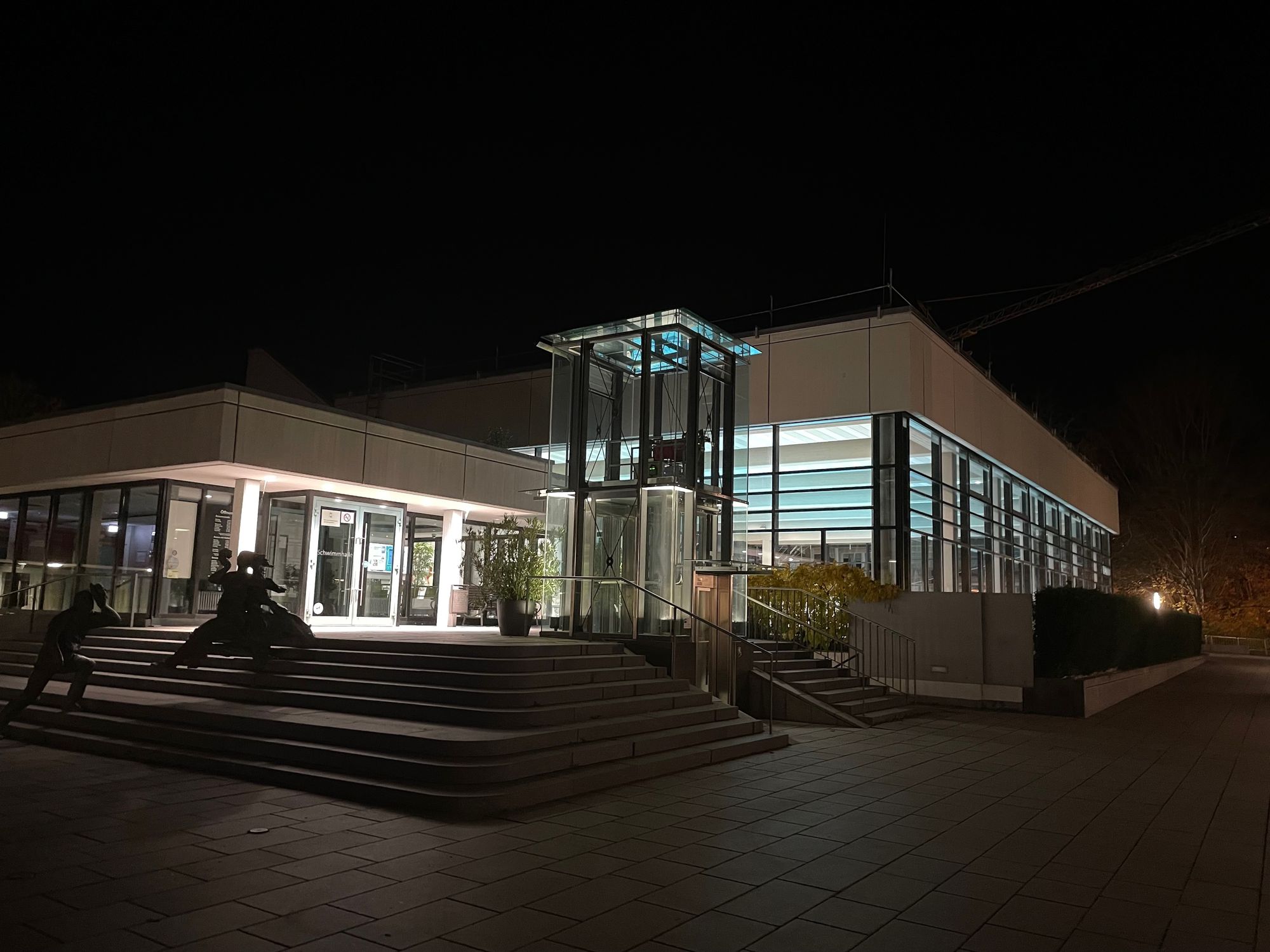 Das Hallenbad der Stadt Gerlingen bei Nacht. Durch die Innenbeleuchtung stahlt es hell. 